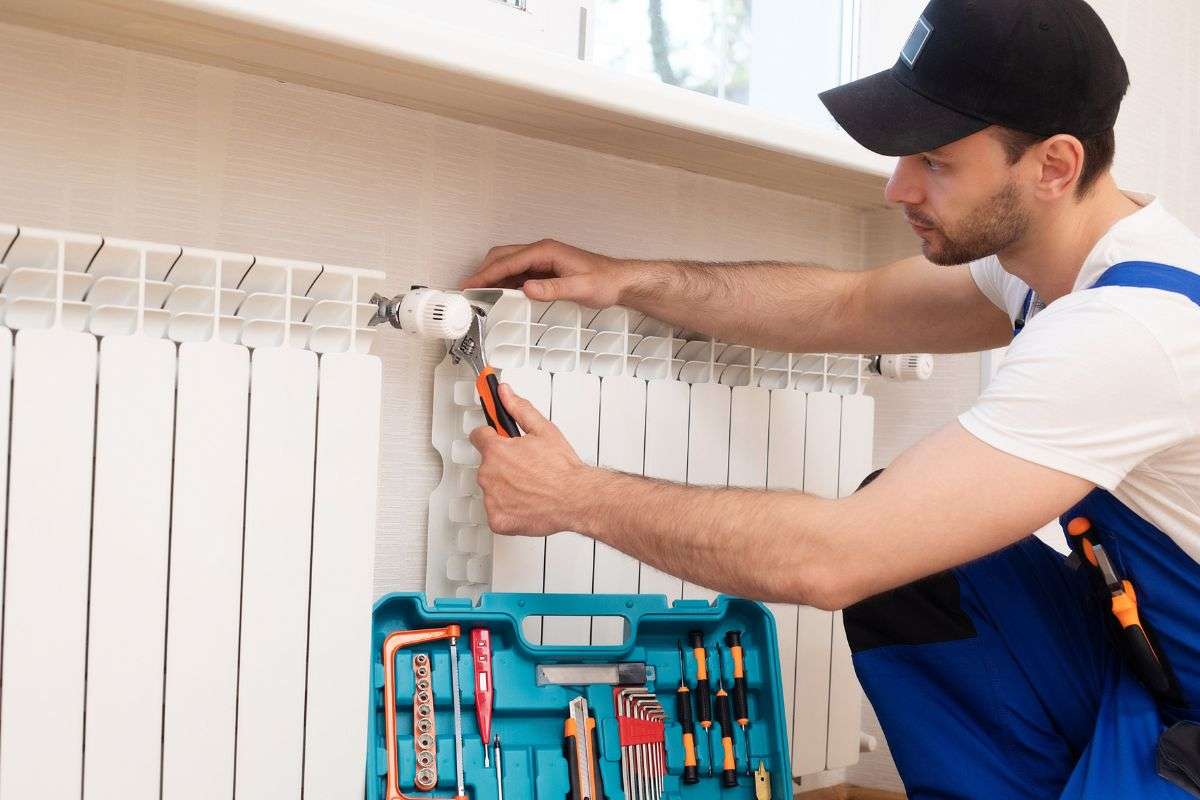 tecnico che ripara termosifoni