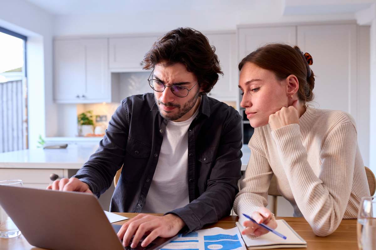 Una coppia spaventata che è preoccupata perché sta guardando le bollette