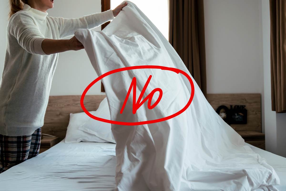 Una donna che cambia le lenzuola del letto