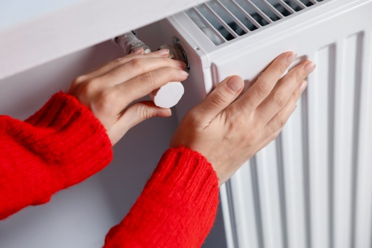 Una persona che accende il termosifone