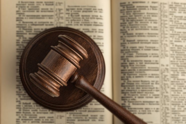 Un libro di legge aperte con sopra un martelletto da giudice