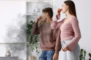 Una coppia che si tappa il naso per l'odore di smog