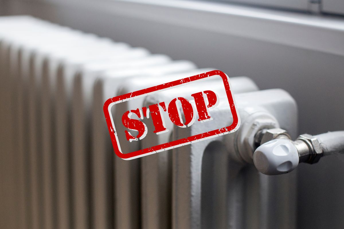 Un termosifone con sopra un segnale di "Stop"