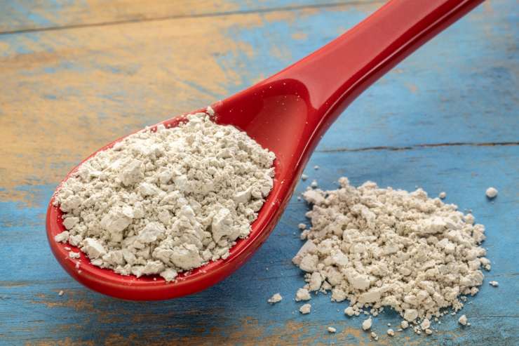 Una foto della terra di diatomee su un tavolo e in un cucchiaio