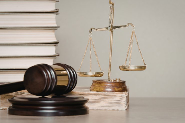 Dei libri di legge uno sopra l'altro con una bilancia ed un martello da giudice