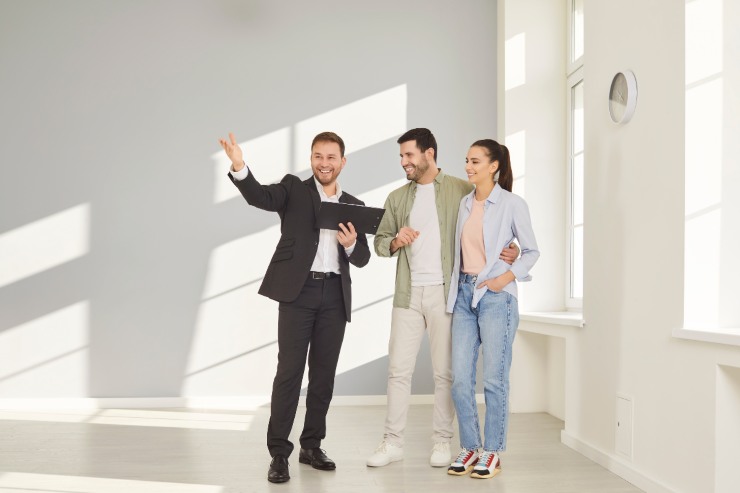 Una coppia che visita la casa con un agente immobiliare che la illustra