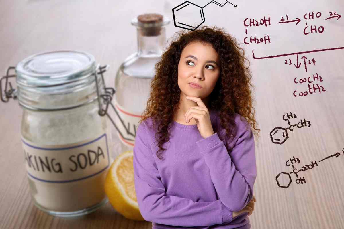 donna che pensa alle reazioni chimiche e sullo sfondo aceto e bicarbonato