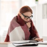 donna con coperta sulle spalle davanti ad un pc