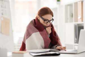 donna con coperta sulle spalle davanti ad un pc