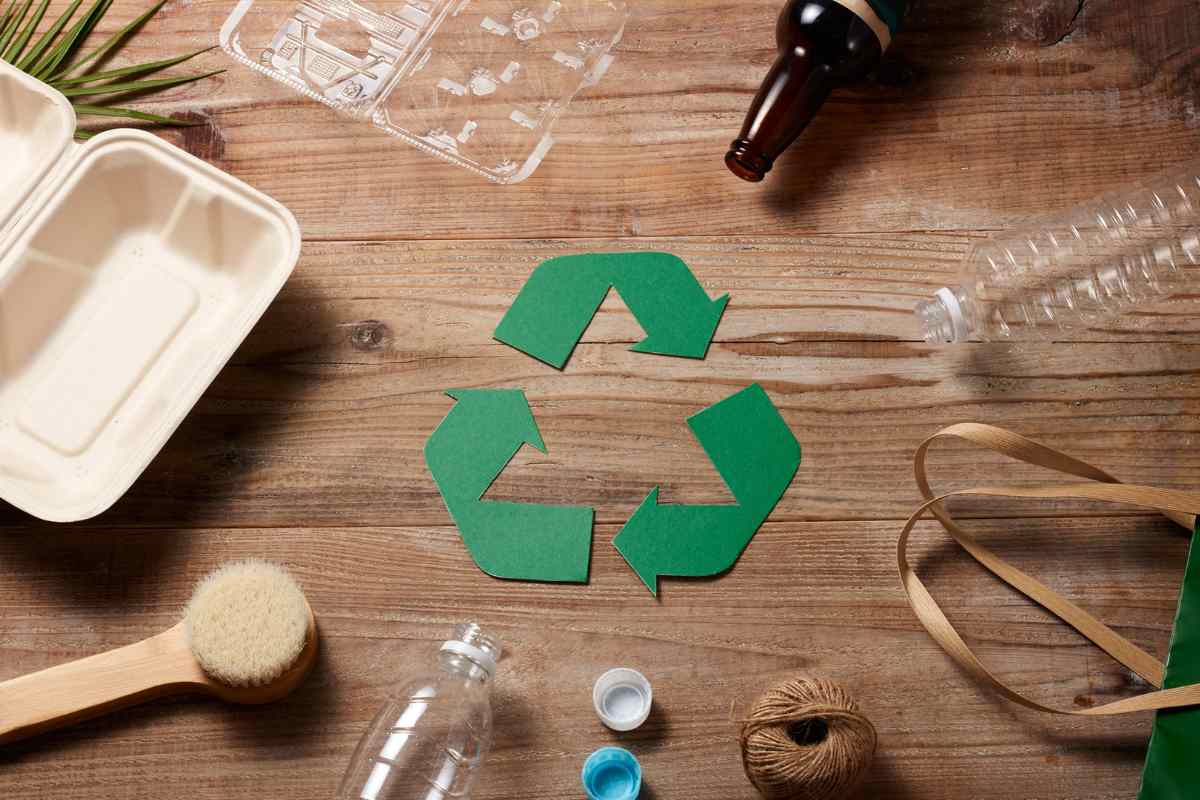 simbolo del riciclo verde e bottiglie di plastica attorno