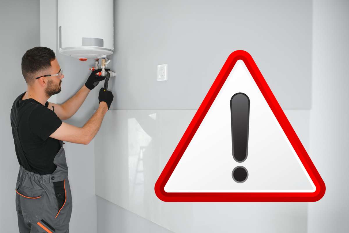 tecnico che cambia caldaia e cartello rosso per attenzione