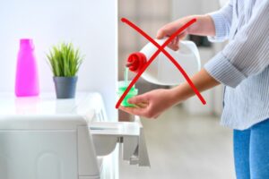 donna che usa ammorbidente per lavatrice ed x rossa su ammorbidente