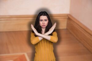 battiscopa di legno e donna che fa stop con le mani