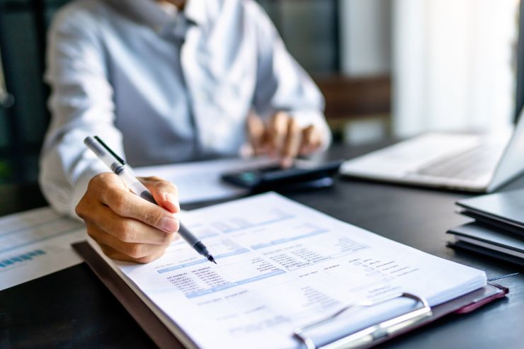 Una amministratore che consulta dei documenti seduto alla sua scrivania