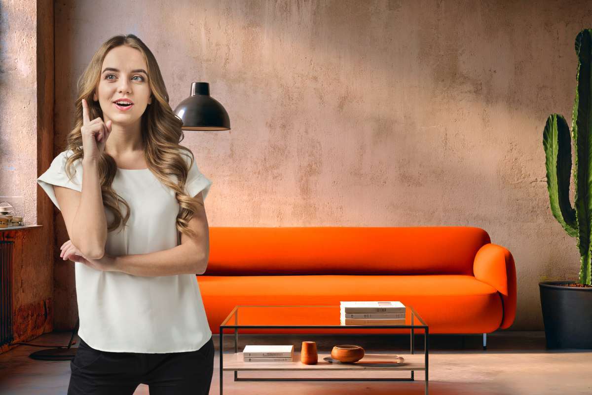 divano arancione con donna con mano in segno di idea