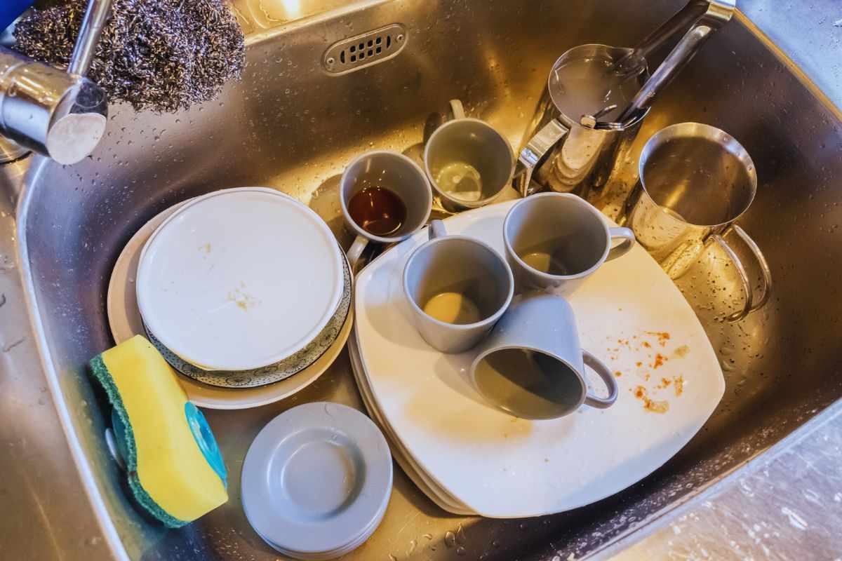 lavello della cucina pieno di stoviglie sporche