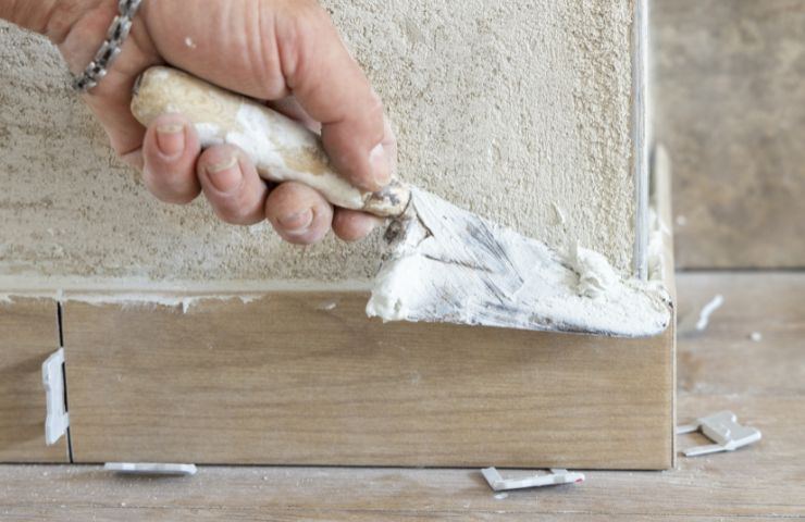 operaio mette battiscopa in casa