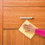 donna che pulisce mobile in legno