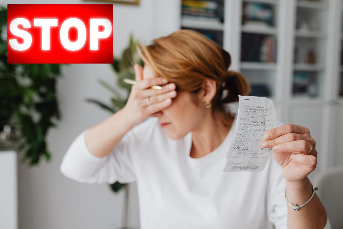 donna con bolletta in mano ed occhi chiusi con scritta stop in rosso