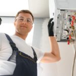 tecnico che lavora sulla caldaia e fa segno ok