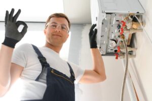 tecnico che lavora sulla caldaia e fa segno ok