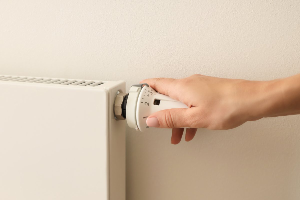 uomo con mano su maniglia del termosifone 