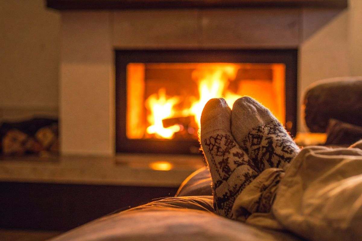 persona su divano che guarda il camino