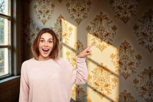 donna che indica una parete con della carta da parati