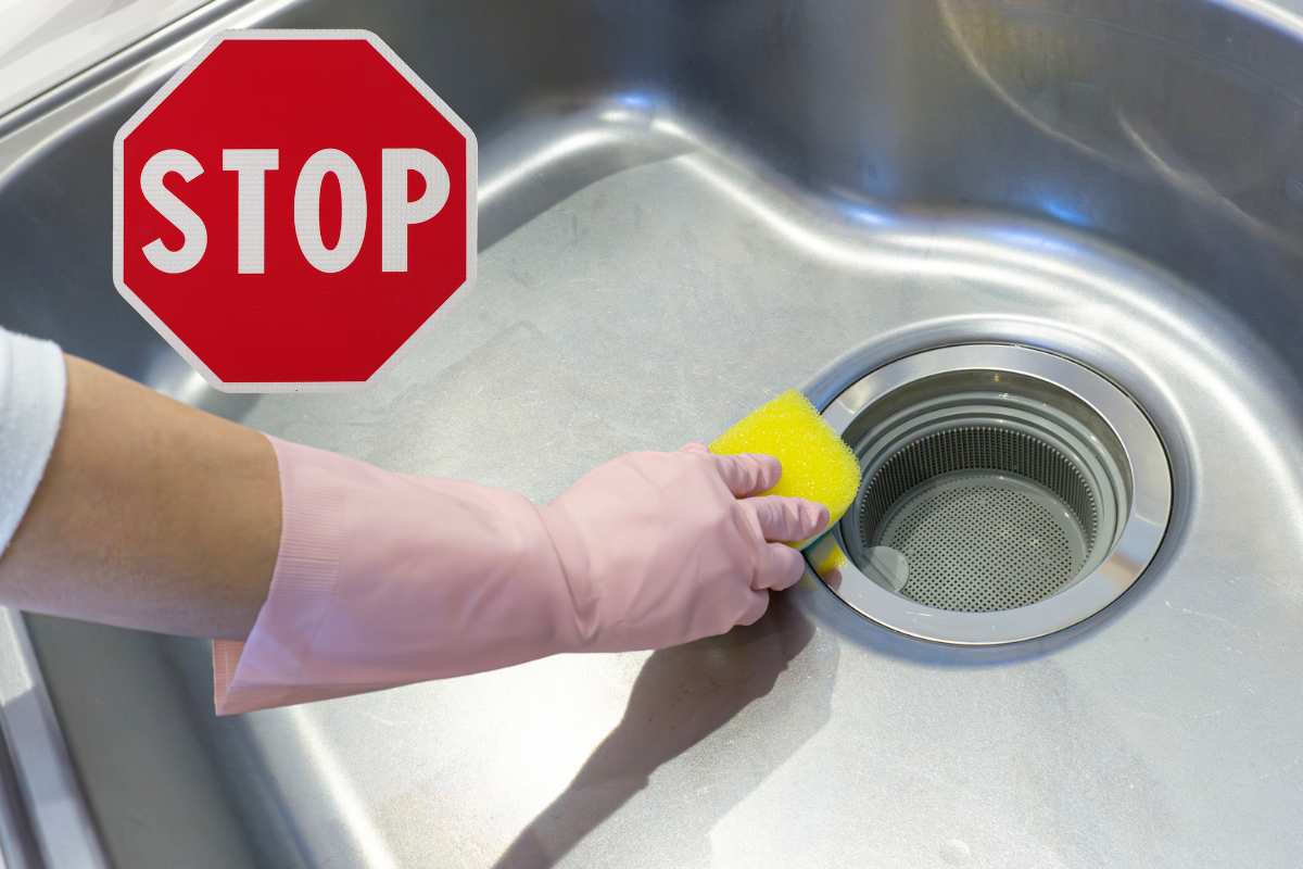 mano che pulisce scarico con scritta stop