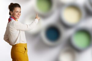 donna che indica colori sfocati sullo sfondo dentro barattoli