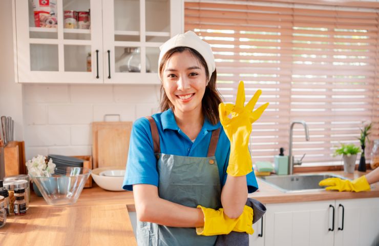 donna delle pulizie sorridente che fa ok con le mani