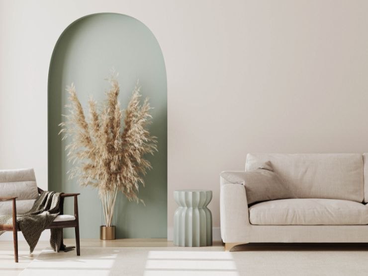 parete di un soggiorno su cui è poggiato un divano bianco con accanto un vaso