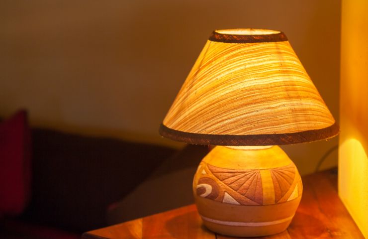 lampada da tavolo poggiata su ripiano in legno