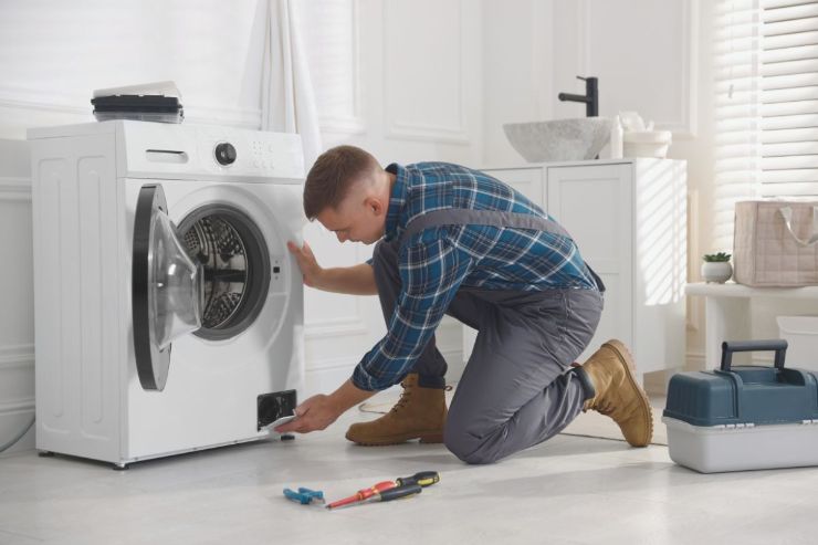 lavatrice e tecnico che esegue riparazione