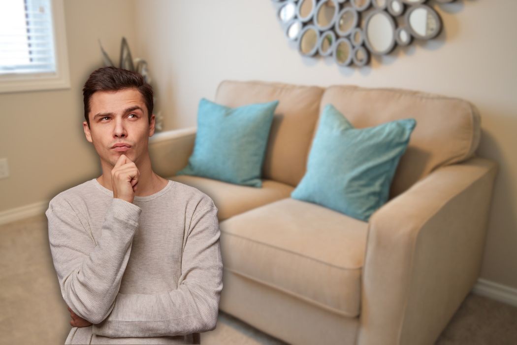 piccolo divano posizionato su una parete e uomo che pensa