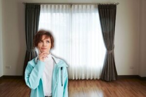 sfondo di una stanza vuoti con finestra e tenda in primo piano una donna che pensa