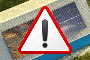 fotovoltaico su tetto di una casa e simbolo di attenzione con bordo rosso