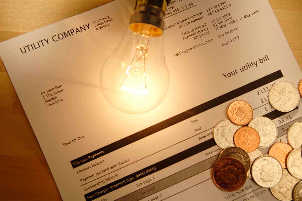 bolletta sulla sfondo con lampadina e monete 