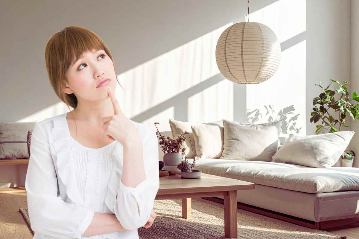 donna che pensa all'arredamento guardando il suo salotto