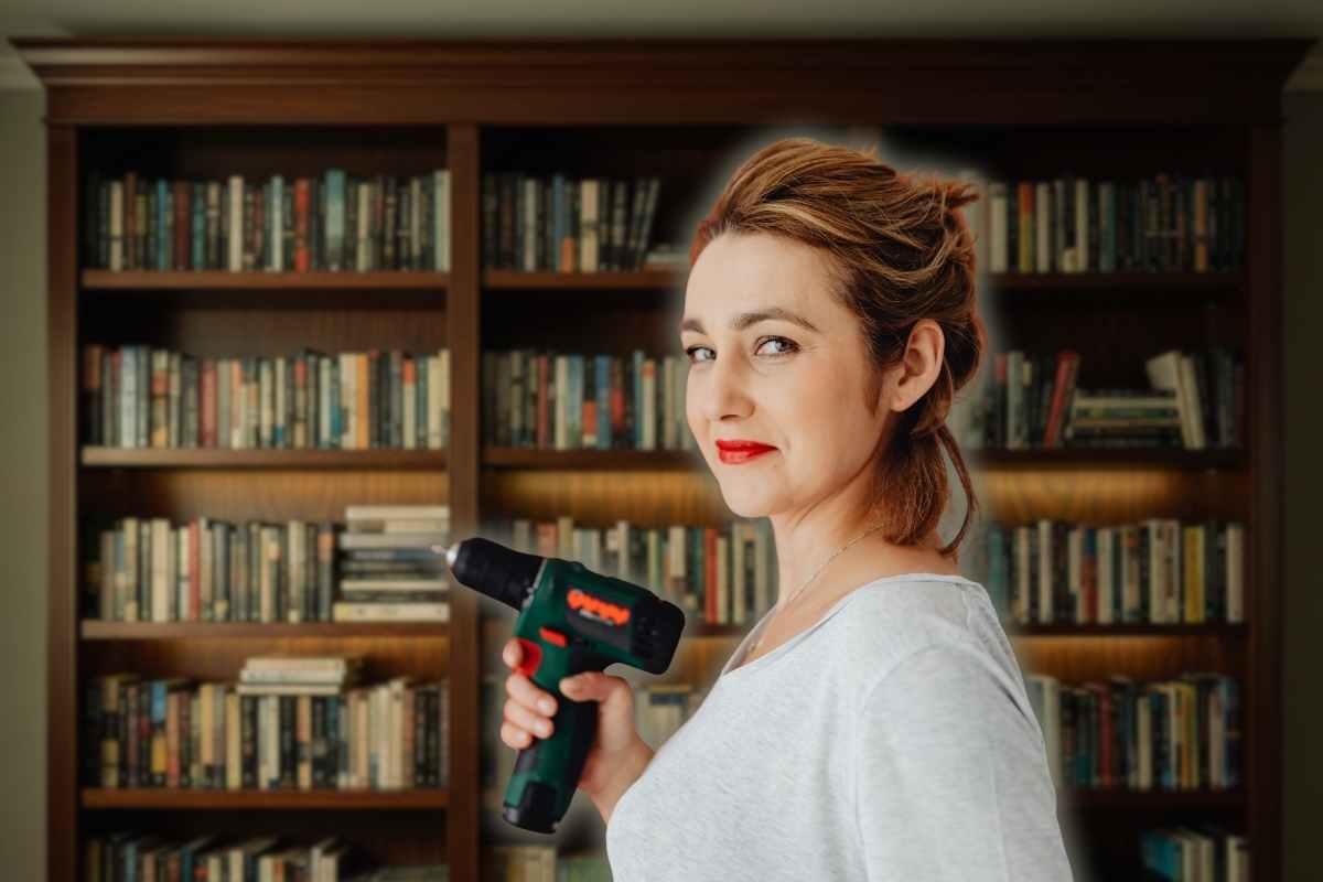 donna con un trapano in mano e una libreria dietro