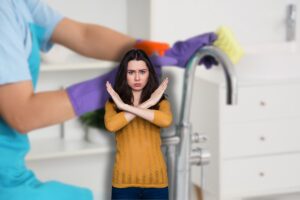 donna che fa le pulizie con spugna e guanti e donna che fa stop con le braccia