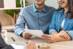 coppia con foglio in mano che parla con agente