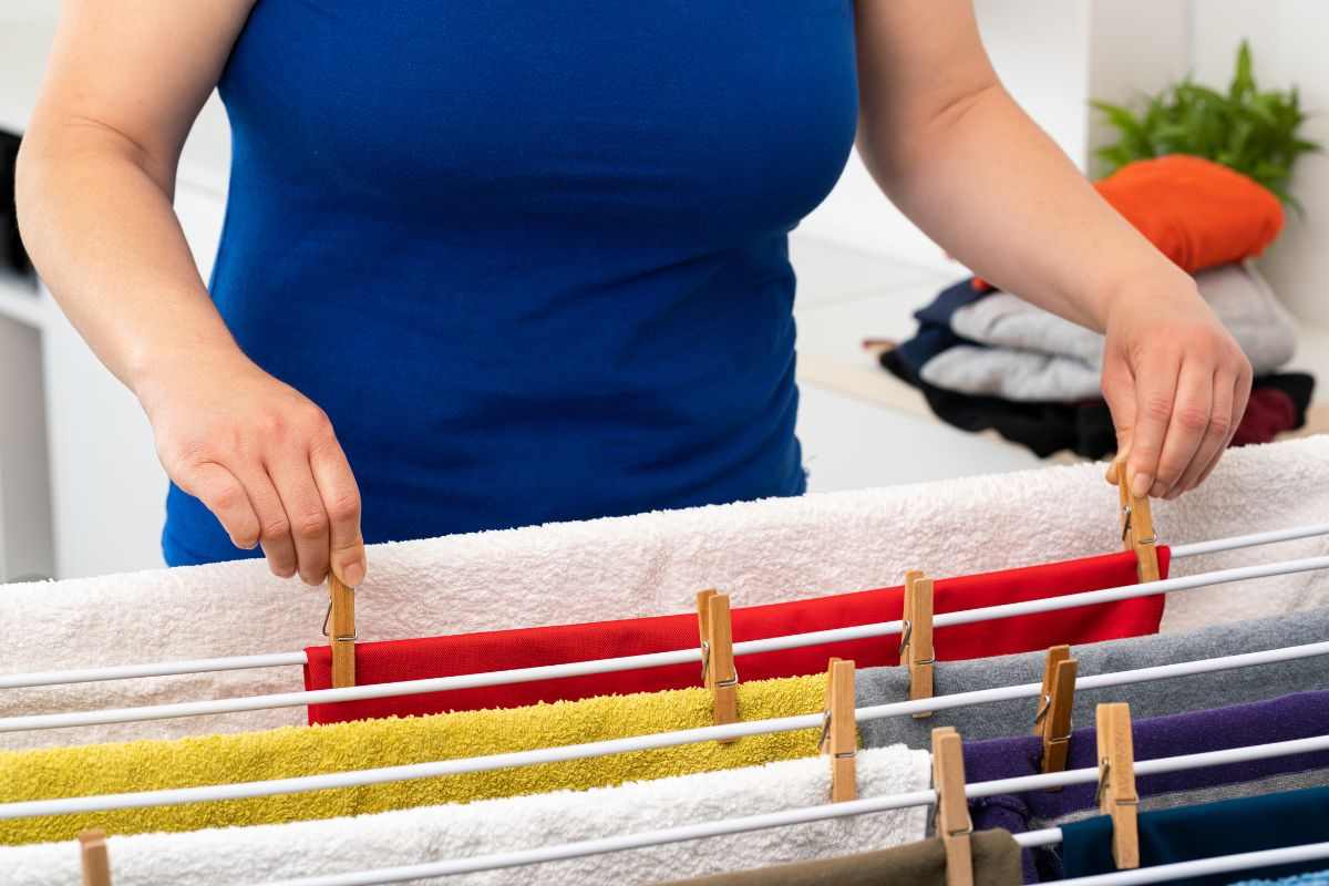 donna che mette mollette su panni in casa