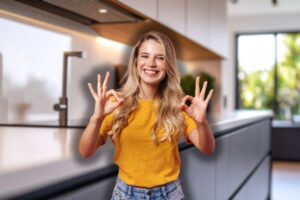 cucina con focus su piano da lavoro sullo sfondo e donna che fa ok con le mani