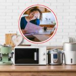 ripiano della cucina pieno di piccoli elettrodomestici e donna che legge bollette