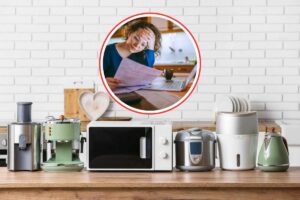ripiano della cucina pieno di piccoli elettrodomestici e donna che legge bollette