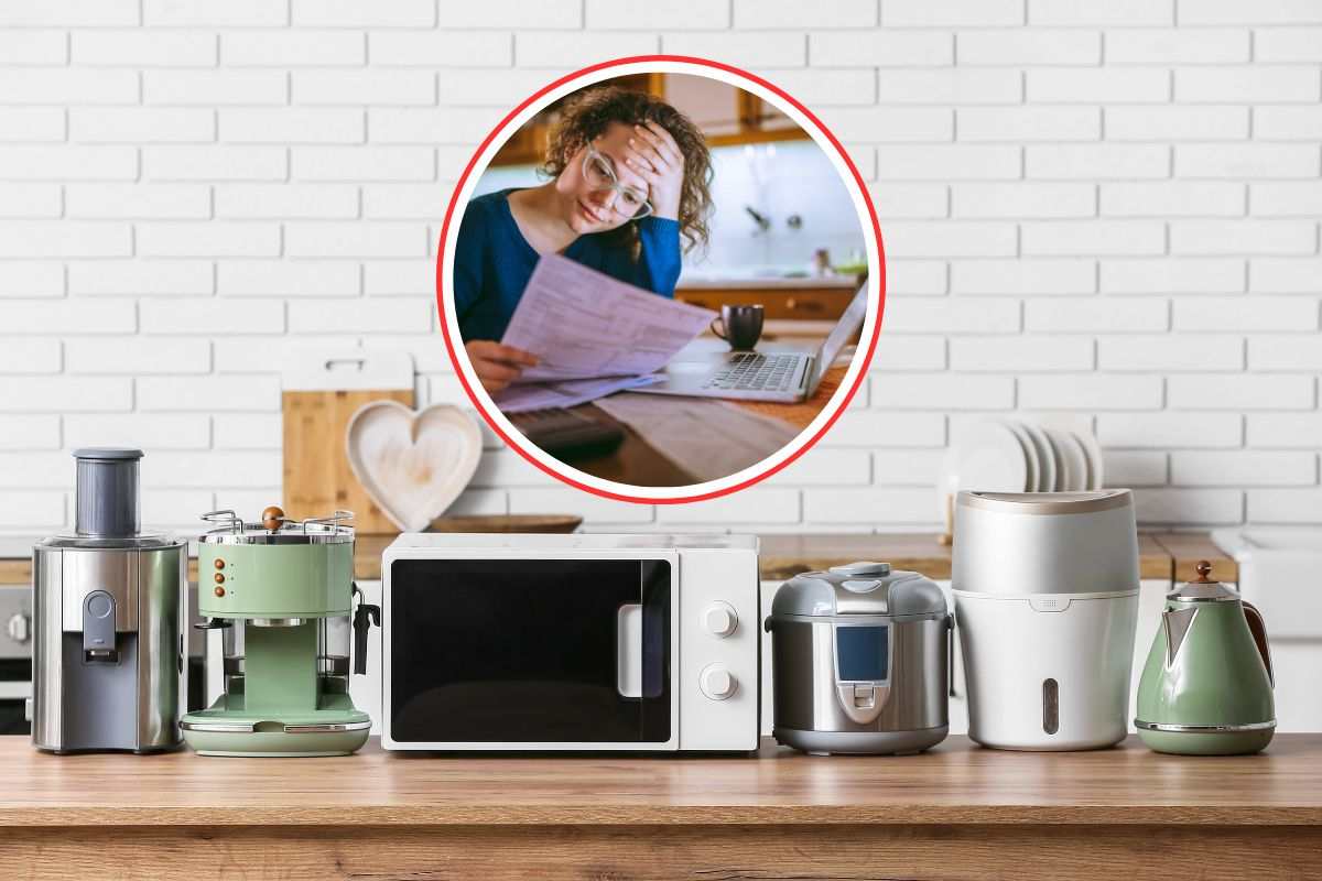 ripiano della cucina pieno di piccoli elettrodomestici e donna che legge bollette