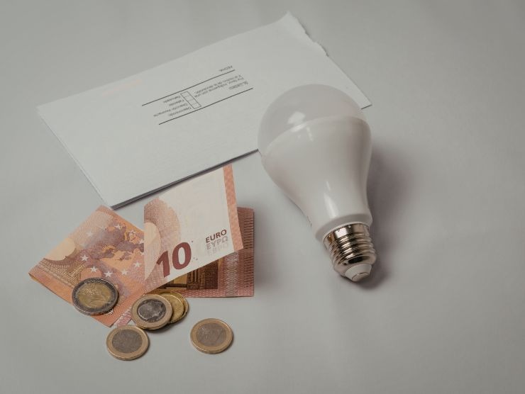 lampadina accanto ad una bolletta e a soldi