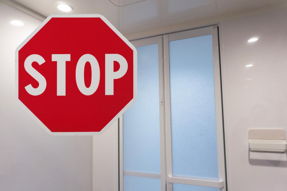 porta del bagno chiusa e cartello con scritto stop