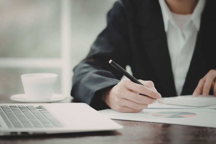 Un uomo che compila dei documenti su una scrivania